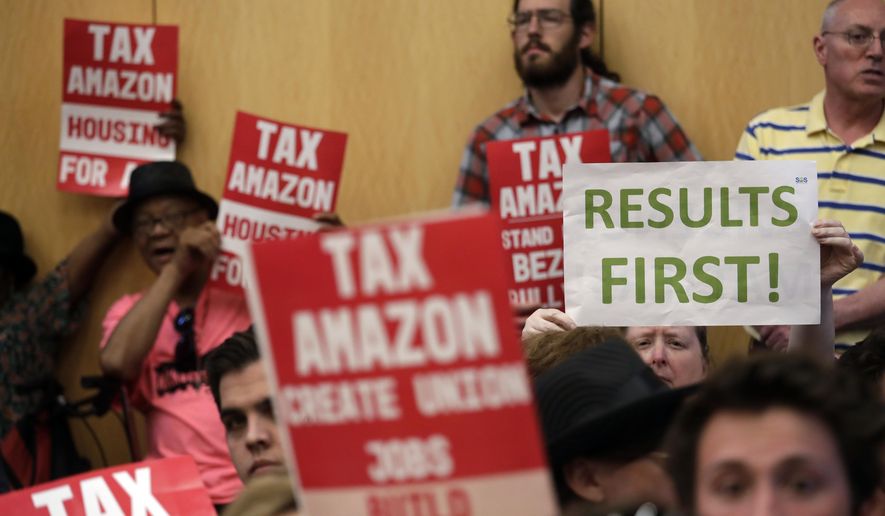 People fill seats before a Seattle City Council meeting where the council was expected to vote on a "head tax" Monday, May 14, 2018, in Seattle. The council is expected to vote Monday on a proposal to tax large businesses such as Amazon and Starbucks to fight homelessness. The plan would tax large businesses about $500 a year per worker to raise about $75 million a year for homeless services and affordable housing. (AP Photo/Elaine Thompson)