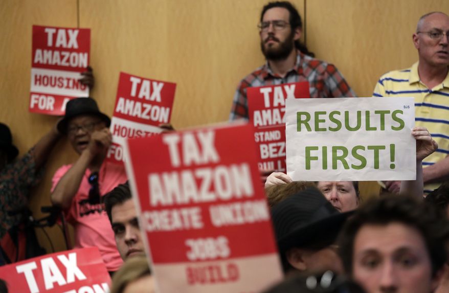 People fill seats before a Seattle City Council meeting where the council was expected to vote on a "head tax" Monday, May 14, 2018, in Seattle. The council is expected to vote Monday on a proposal to tax large businesses such as Amazon and Starbucks to fight homelessness. The plan would tax large businesses about $500 a year per worker to raise about $75 million a year for homeless services and affordable housing. (AP Photo/Elaine Thompson)