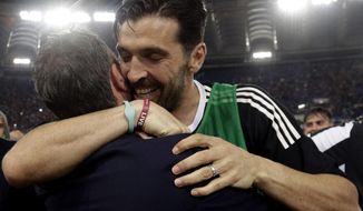 Juventus goalkeeper Gianluigi Buffon celebrates with a team staffer at the end of the Serie A soccer match between Roma and Juventus, at the Rome Olympic stadium, Sunday, May 13, 2018. The match ended in a scoreless draw and Juventus won record-extending seventh straight Serie A title. (AP Photo/Gregorio Borgia)