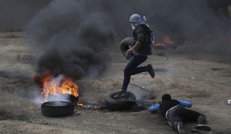 Palestinian protesters burn tires during a protest on the Gaza Strip&#x27;s border with Israel, Monday, May 14, 2018. Thousands of Palestinians are protesting near Gaza&#x27;s border with Israel, as Israel prepared for the festive inauguration of a new U.S. Embassy in contested Jerusalem. (AP Photo/Khalil Hamra)