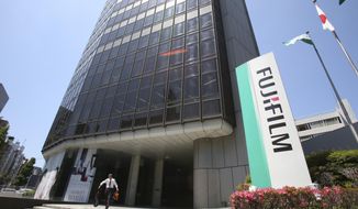 A man walks in front of Nishiazabu headquarters of Fujifilm Holdings Corporation in Tokyo, Monday, May 14, 2018.  Copier company Xerox Corp. said Sunday it was ending an agreement to combine with Japan&#x27;s Fujifilm Holdings and is entering a settlement deal with investors Carl Icahn and Darwin Deason.(AP Photo/Koji Sasahara)