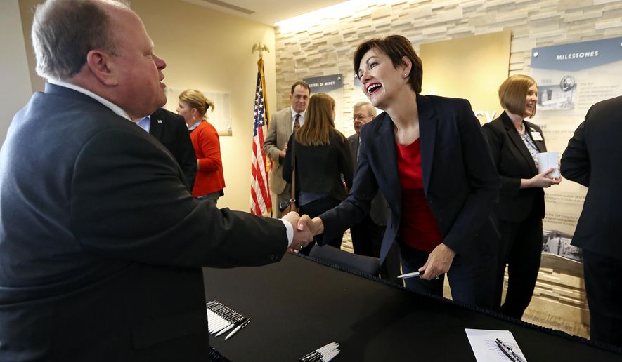 Iowa Gov. Kim Reynolds, front right, talks with Joe Lock, president and CEO of Eastern Iowa Health Center, after signing House File 2377, also known as the opioid bill, at Mercy Medical Center-Dubuque on Monday, May 14, 2018, in Dubuque, Iowa. (Nicki Kohl/Telegraph Herald via AP)