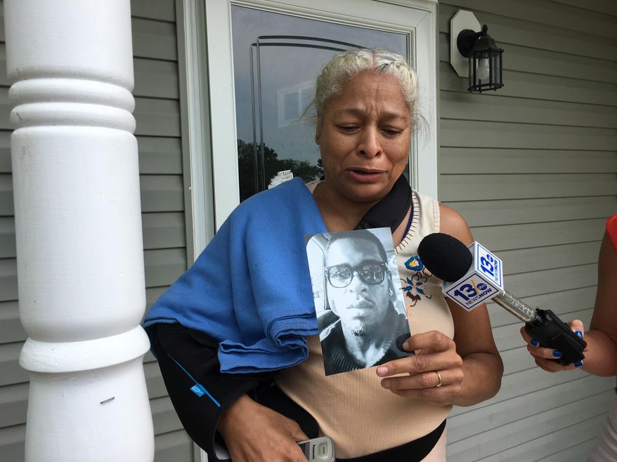 Lorri Flythe holds a photo of her son Willie Marable outside their house in Portsmouth, Va., on Monday, May 14, 2018. Police said Marable was an armed home-invasion suspect who was shot and killed by an officer after he refused to surrender. Flythe said her son didn’t own a gun and would have had trouble shooting it because he had an impaired hand. The shooting remains under investigation. (AP Photo / Ben Finley)