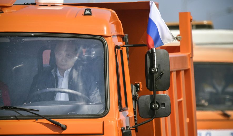 Russian President Vladimir Putin drives a truck to officially open the much-anticipated bridge linking Russia and the Crimean peninsula, during the opening ceremony near in Kerch, Crimea, Tuesday, May 15, 2018. Putin has taken to the wheel of a truck to officially open the bridge linking Russia's south and the Crimean peninsula that Russia annexed from Ukraine in 2014. (Alexander Nemenov/Pool Photo via AP)