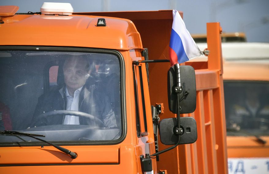 Russian President Vladimir Putin drives a truck to officially open the much-anticipated bridge linking Russia and the Crimean peninsula, during the opening ceremony near in Kerch, Crimea, Tuesday, May 15, 2018. Putin has taken to the wheel of a truck to officially open the bridge linking Russia's south and the Crimean peninsula that Russia annexed from Ukraine in 2014. (Alexander Nemenov/Pool Photo via AP)