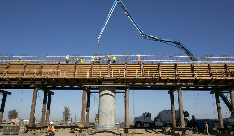 FILE - In this Dec. 6, 2017, file, workers pour concrete on to one of the elevated sections of the high-speed rail that will cross over the San Joaquin River, near Fresno, Calif. California California's high-speed rail board has approved a 2018 business plan that outlines the challenges in completing the ambitious project to build a bullet train between Los Angeles and San Francisco by 2033. The board's Tuesday, May 15, 2018, vote comes after two months of feedback from lawmakers and the public. (AP Photo/Rich Pedroncelli, File)