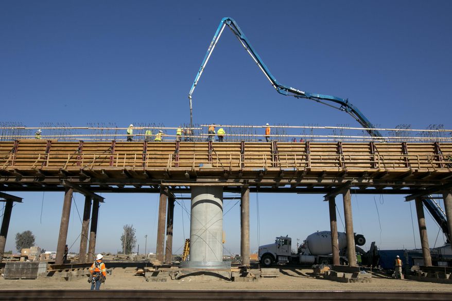 FILE - In this Dec. 6, 2017, file, workers pour concrete on to one of the elevated sections of the high-speed rail that will cross over the San Joaquin River, near Fresno, Calif. California California's high-speed rail board has approved a 2018 business plan that outlines the challenges in completing the ambitious project to build a bullet train between Los Angeles and San Francisco by 2033. The board's Tuesday, May 15, 2018, vote comes after two months of feedback from lawmakers and the public. (AP Photo/Rich Pedroncelli, File)