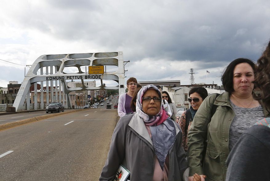 Members of the Sisterhood of Salaam Shalom group walk across the historic Edmund Pettus Bridge in Selma, Ala., on Tuesday, April, 24, 2018. The Sisterhood of Salaam Shalom brings together Jewish and Muslim women interested in learning about one another. (AP Photo/Brynn Anderson)