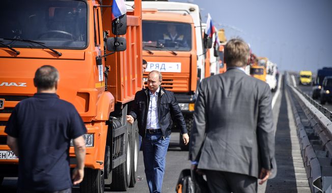 Russian President Vladimir Putin walks after driving a truck to officially open the much-anticipated bridge linking Russia and the Crimean peninsula, during the opening ceremony near in Kerch, Crimea, Tuesday, May 15, 2018. Putin has taken to the wheel of a truck to officially open the bridge linking Russia&#x27;s south and the Crimean peninsula that Russia annexed from Ukraine in 2014. (Alexander Nemenov/Pool Photo via AP) **FILE**