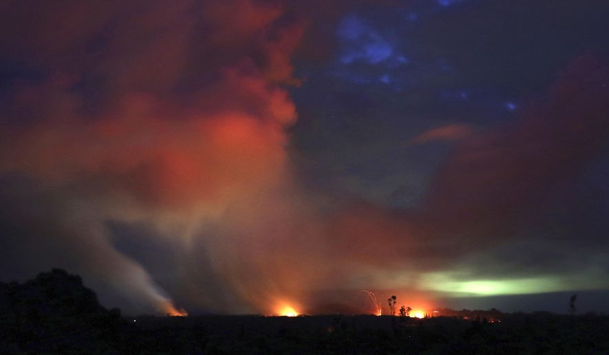Lava shoots into the night sky from active fissures on the lower east rift of the Kilauea volcano, Tuesday, May 15, 2018, near Pahoa, Hawaii. (AP Photo/Caleb Jones)