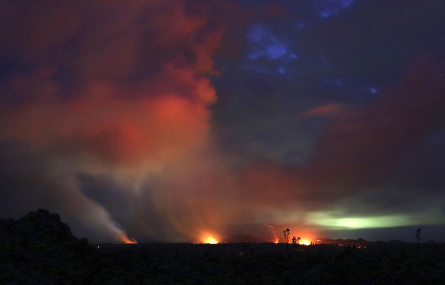 Lava shoots into the night sky from active fissures on the lower east rift of the Kilauea volcano, Tuesday, May 15, 2018, near Pahoa, Hawaii. (AP Photo/Caleb Jones)