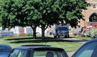 An emergency vehicle appears outside Dixon High School Wednesday, May 16, 2018 in Dixon, Ill. Officials say a police officer has shot and wounded a gunman at a northern Illinois high school. The Dixon city manager Danny Langloss says police confronted a former male student with a gun on school property about 8 a.m. Wednesday. Langloss says the gunman shot at an officer who returned fire and hit him. He is in custody with what Langloss described as non-life-threatening injuries. (Rachel Rogers/Sauk Valley Media via AP)