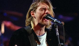 FILE - This Dec. 13, 1993 file photo shows Kurt Cobain of the band Nirvana performing in Seattle. The Washington State Court of Appeals has ruled that photographs from the scene of Nirvana frontman Cobain’s death will not be released publicly. KING5-TV reports the court ruled Tuesday, May 15, 2018, that the photographs are exempt from Washington state’s Public Records Act and releasing the photos would “violate the Cobain family’s due process rights under the 14th Amendment.”  (AP Photo/Robert Sorbo, File)