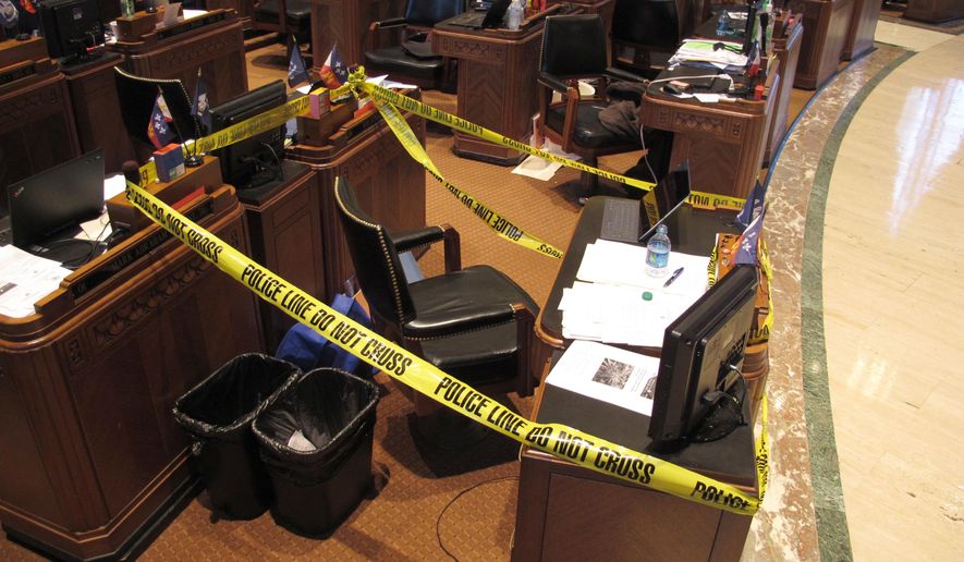 Lawmakers in the House roped off the area around Rep. Stuart Bishop's desk, on Wednesday, May 16, 2018, in Baton Rouge, La. The police tape was a joke after Bishop, R-Lafayette, got into a bar fight with Sen. Norby Chabert, a Houma Republican, a night earlier. Both say they regret the fight and consider themselves friends. (AP Photo/Melinda Deslatte)