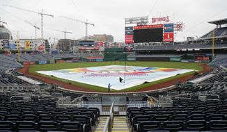 A tarp covers the infield at Nationals Park in Washington after it was announced that the baseball game between the Los Angeles Dodgers and the Washington Nationals had been postponed due to inclement weather, Friday, May 18, 2018. The game will be made up as part of a split doubleheader Saturday. (AP Photo/Pablo Martinez Monsivais)