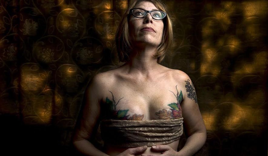 Andrea Reynolds, who had a double mastectomy in 2013, shows the artistry of Fallen Angel Tattoos founder and owner Terrina Francis, Friday, April 20, 2018 in her Utah home. Francis tattooed leaves and branches over Reynolds&#x27; reconstructive surgery scars in 2014. The all-women tattoo shop specializes in helping women who have had breast cancer and reconstructive surgery by tattooing art on their bodies to cover scars.  (Leah Hogsten/The Salt Lake Tribune via AP)