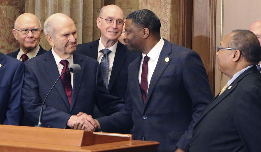 FILE - In a Thursday, May 17, 2018 file photo, Mormon church President Russell M. Nelson shakes hands with Derrick Johnson, president of the NAACP during a news conference, in Salt Lake City. The Mormon church did not issue an apology for a “history of racism” during a news conference this week with NAACP leaders, despite a false news release posted on a website made to look strikingly similar to one used by the church. (AP Photo/Rick Bowmer, File)