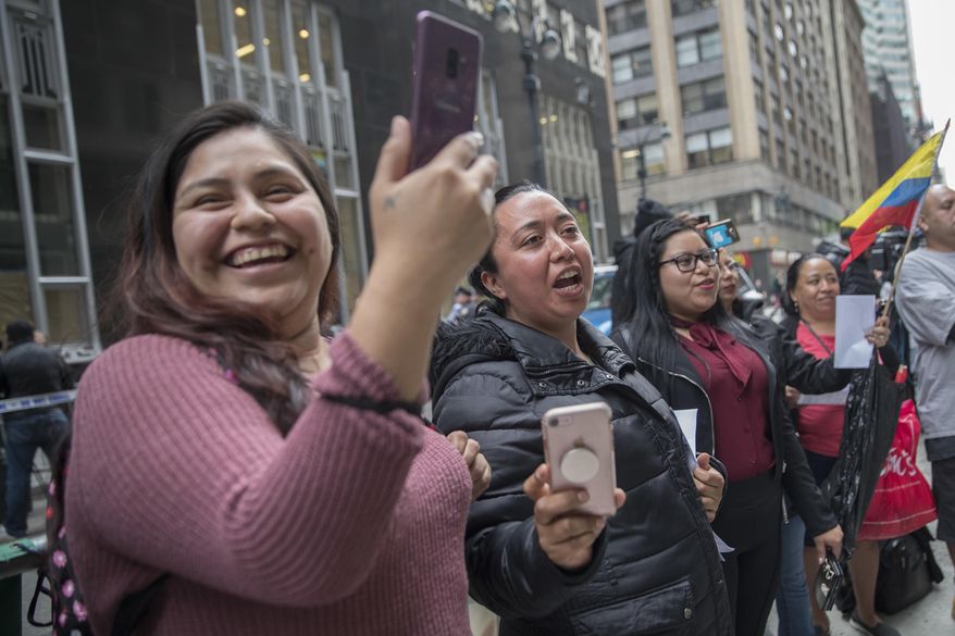 Demonstrator sing along as the Mariachi Tapatio de Alvaro Paulino band performs during a demonstration across the street from the building that once housed the office space of Aaron Schlossberg, Friday, May 18, 2018, in New York. Schlossberg, a lawyer who was caught on video ranting against Spanish-speaking restaurant workers has been kicked out of his office space and faces a complaint from two elected officials. (AP Photo/Mary Altaffer)