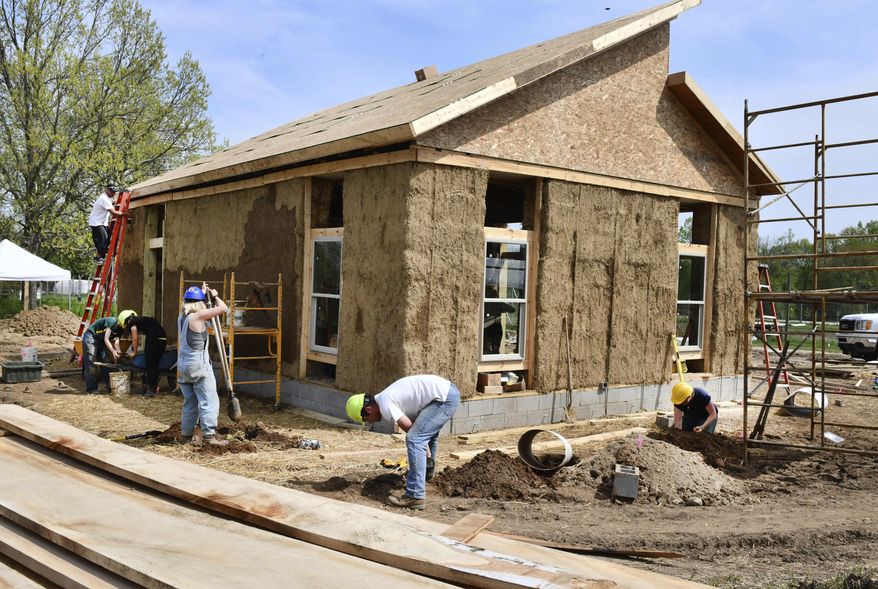 University of Michigan students take part in a Green Building class, constructing a straw bale dwelling at the UM Campus Farm at Matthaei Botanical Gardens in Ann Arbor, Michigan on Thursday, May 17, 2018. (Daniel Mears/Detroit News via AP)