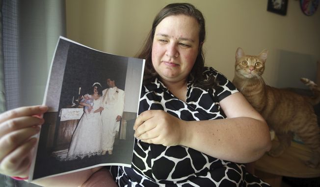 Heidi Clark holds a photograph from her 1995 wedding at her home in Orem, Utah, on Friday, May 18, 2018. Clark became pregnant at 16 and married soon after, under pressure from her boyfriend's religious community of Seventh-Day Adventists in Pennsylvania, she said. “I always felt a little bit like I was trapped,” Clark said, now 40. “I was 17. I was so young.” Utah state Rep. Angela Romero wants to ban marriage for anyone under 18 as part of a national push to outlaw underage marriage. (AP Photo/Rick Bowmer)