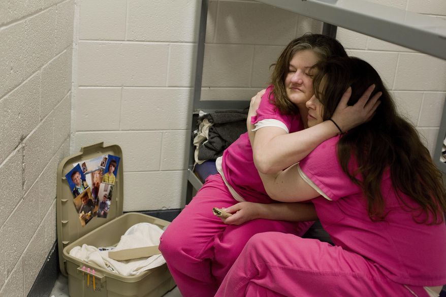 ADVANCE FOR USE MONDAY, MAY 21, 2018 AND THEREAFTER-Inmate Crystal French, 38, left, is comforted by cellmate Krystle Sweat, 32, at the Campbell County Jail in Jacksboro, Tenn., Tuesday, March 30, 2018, after French was denied parole the previous day. She won't be eligible again for another year. "I got to know the real me again instead of the addicted-to-drugs person. I'd like to be a productive citizen, not an OD statistic, end up dying on drugs," said French, whose two sons are being raised by her ex-husband. "I am a good person. I know I am. But I want to see that person again." (AP Photo/David Goldman)