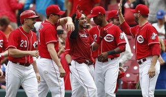 Cincinnati Reds&#39; Billy Hamilton, center, celebrates the team&#39;s 5-4 win over the Chicago Cubs in 11 innings in the first baseball game of a doubleheader, Saturday, May 19, 2018, in Cincinnati. The Reds won 5-4. (AP Photo/Gary Landers)