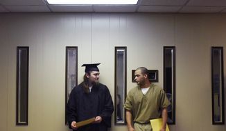 In this Thursday, May 10, 2018 photo, Kameron Reynolds, left, and Fabian Ramos speak to each other after their graduation ceremony at the South Dakota State Penitentiary in Sioux Falls, S.D. Twenty inmates at the South Dakota State Penitentiary in Sioux Falls have earned their general equivalency diplomas. (Loren Townsley/The Argus Leader via AP)