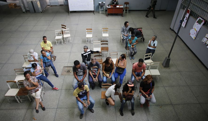 People wait their turn to vote during the presidential election in Caracas, Venezuela, Sunday, May 20, 2018. Amidst hyperinflation and shortages of food and medicine, President Nicolas Maduro is seeking a second, six-year term in an election that a growing chorus of foreign governments refuse to recognize after key opponents were barred from running. (AP Photo/Ariana Cubillos)