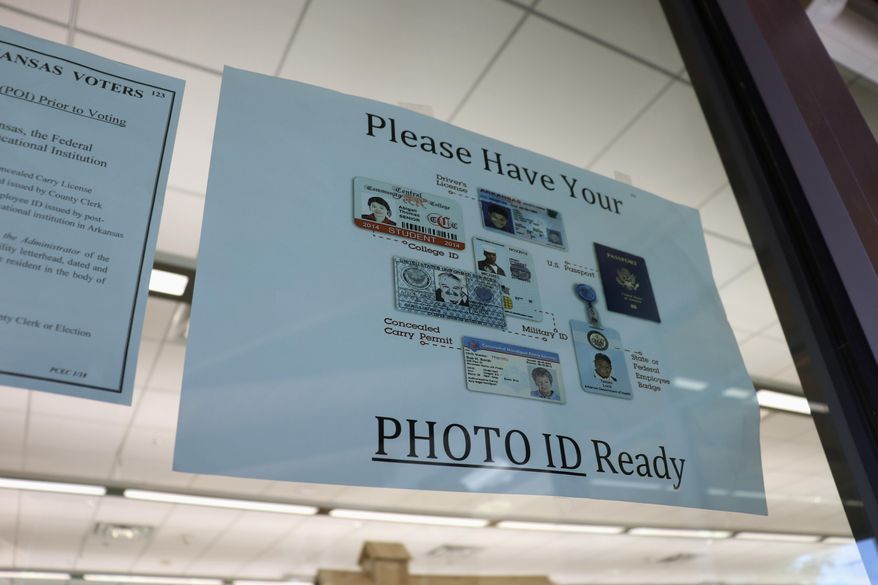 In this May 7, 2018, photo, a sign is posted above the check-in station for an early voting precinct at the Roosevelt Thompson Library in Little Rock, Ark., warning voters that they will be asked to show an identification card. Democratic and Republican voters on Tuesday, May 22, 2018, will choose nominees for the November general election, and all voters are eligible to vote in non-partisan court and prosecuting attorney races. (AP Photo/Kelly P. Kissel)