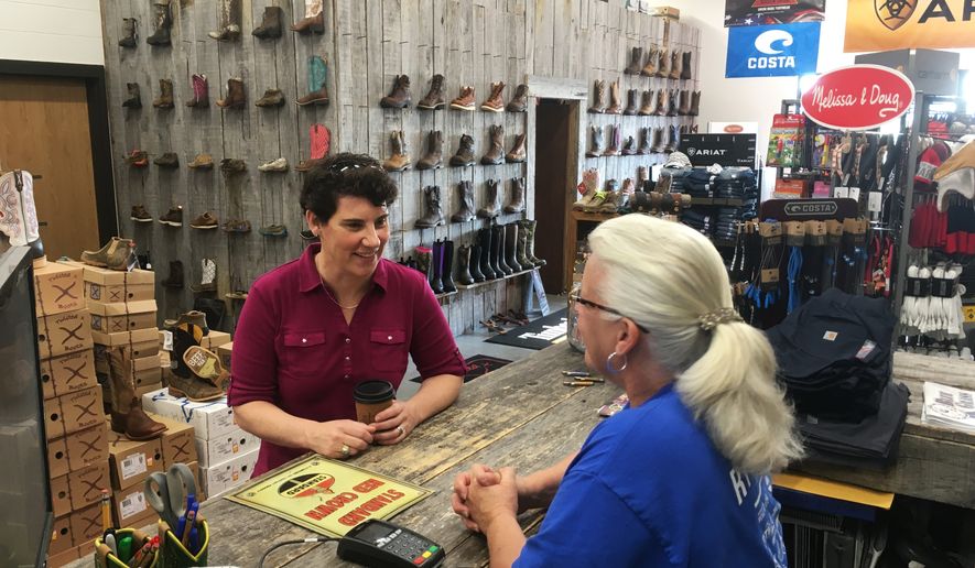 Kentucky 6th Congressional District Democratic candidate Amy McGrath, left, speaks with Vonnie Gesinske at RT Outfitters on Monday, May 21, 2018, in Lexington, Ky. McGrath is one of several candidates seeking the Democratic nomination in Tuesday’s primary election for the chance to challenge likely Republican nominee Andy Barr, a three-term incumbent. (AP Photo/Adam Beam)