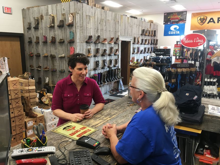 Kentucky 6th Congressional District Democratic candidate Amy McGrath, left, speaks with Vonnie Gesinske at RT Outfitters on Monday, May 21, 2018, in Lexington, Ky. McGrath is one of several candidates seeking the Democratic nomination in Tuesday’s primary election for the chance to challenge likely Republican nominee Andy Barr, a three-term incumbent. (AP Photo/Adam Beam)