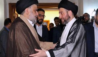 In this photo provided by the Sadr Media Office, Shiite cleric Muqtada al-Sadr, left, greets Shiite leader Ammar al-Hakim on his arrival for their meeting in Baghdad, Iraq, early Tuesday, May 22, 2018. (Sadr Media Office via AP)