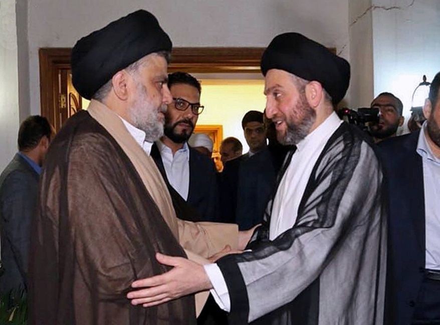 In this photo provided by the Sadr Media Office, Shiite cleric Muqtada al-Sadr, left, greets Shiite leader Ammar al-Hakim on his arrival for their meeting in Baghdad, Iraq, early Tuesday, May 22, 2018. (Sadr Media Office via AP)