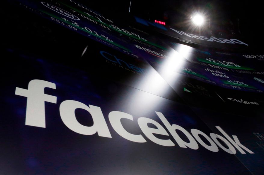 In this March 29, 2018, file photo the logo for Facebook appears on screens at the Nasdaq MarketSite in New York's Times Square. (AP Photo/Richard Drew, File)