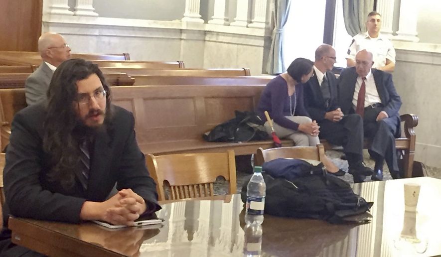 Michael Rotondo, left, sits during an eviction proceeding in Syracuse, N.Y., brought by his parents, Mark and Christina, of Camillus. The two parents confer with their lawyer, Anthony Adorante, in the court gallery behind. Rotondo told the judge Tuesday, May 22, 2018, he knows his parents want him out of their Camillus home, near Syracuse. But he argued he’s entitled to six months more time. (Douglass Dowty /The Syracuse Newspapers via AP)