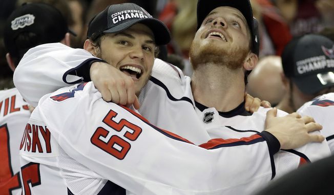 Washington Capitals left wing Andre Burakovsky (65) and defenseman John Carlson celebrate after the Capitals defeated the Tampa Bay Lightning 4-0 during Game 7 of the NHL Eastern Conference finals hockey playoff series Wednesday, May 23, 2018, in Tampa, Fla. (AP Photo/Chris O&#x27;Meara)