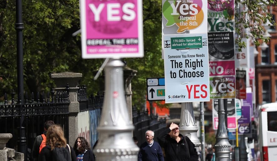 In this photo taken on May 17, 2018, Pro and anti-abortion poster&#x27;s on lamppost&#x27;s outside government buildings in Dublin, Ireland. In homes and pubs, on leaflets and lampposts, debate rages in Ireland over whether to lift the country&#x27;s decades-old ban on abortion. Pro-repeal banners declare: &quot;Her choice: vote yes.&quot; Anti-abortion placards warn against a &quot;license to kill.&quot; Online, the argument is just as charged _ and more shadowy _ as unregulated ads of uncertain origin battle to sway voters ahead of Friday&#x27;s referendum, which could give Irish women the right to end their pregnancies for the first time.  (AP Photo/Peter Morrison)