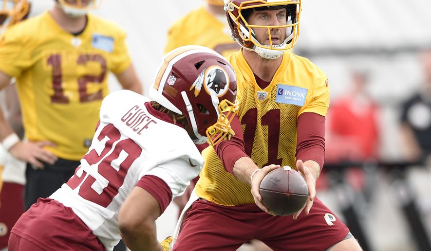 Washington Redskins quarterback Alex Smith (11) hands off to running back Derrius Guice (29) during an NFL football team practice, Wednesday, May 23, 2018, in Ashburn, Va. (AP Photo/Nick Wass) **FILE**