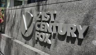 FILE - This Aug. 1, 2017, file photo shows the Twenty-First Century Fox sign outside of the News Corporation headquarters building in New York. Comcast says it’s considering making an offer to buy Twenty-First Century Fox, which would put it in a head-to-head bidding fight with Disney. (AP Photo/Richard Drew, File)