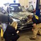 In this March 20, 2018, file photo provided by the National Transportation Safety Board, investigators examine a driverless Uber SUV that fatally struck a woman in Tempe, Ariz. Uber announced Wednesday, May 23, that it is pulling its self-driving cars out of Arizona, a reversal triggered by the recent death of woman who was run over by one of the ride-hailing service&#39;s robotic vehicles while crossing a darkened street in a Phoenix suburb. (National Transportation Safety Board via AP, File)