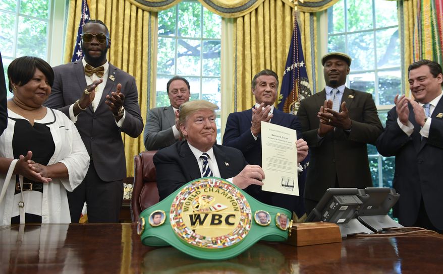President Donald Trump center, posthumous pardons Jack Johnson, boxing&#39;s first black heavyweight champion, during an event in the Oval Office of the White House in Washington, Thursday, May 24, 2018. Trump is joined by, from left, Linda Haywood, who is Johnson&#39;s great-great niece, heavyweight champion Deontay Wilder, Keith Frankel, Sylvester Stallone, former heavyweight champion Lennox Lewis, and World Boxing Council President Mauricio Sulaiman Saldivar. (AP Photo/Susan Walsh)