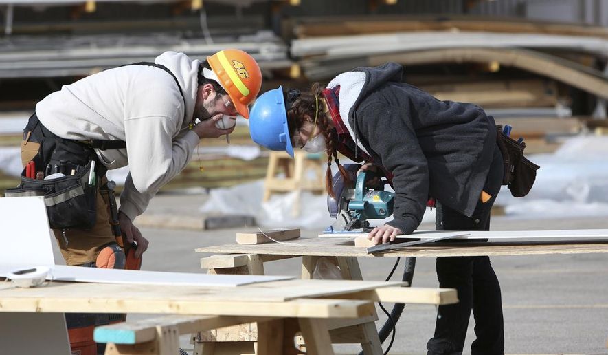 ADVANCE FOR MONDAY, MAY 28 AND THEREAFTER Marie Ptak, right, uses a circular saw as Martin Gutierrez, both students, looks on during a Construction Techniques II class at Madison College in Madison, on Friday, March 30, 2018. (Michelle Stocker/The Capital Times via AP)