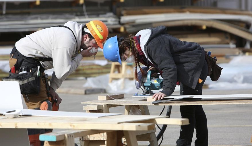 ADVANCE FOR MONDAY, MAY 28 AND THEREAFTER Marie Ptak, right, uses a circular saw as Martin Gutierrez, both students, looks on during a Construction Techniques II class at Madison College in Madison, on Friday, March 30, 2018. (Michelle Stocker/The Capital Times via AP)