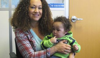 FILE - In this March 20, 2017, file photo, Rachel Dolezal poses for a photo with her son, Langston, at the bureau of The Associated Press in Spokane, Wash. Dolezal, a former NAACP leader in Washington state whose life unraveled after she was outed as a white woman pretending to be black, has been charged with welfare fraud, news station KHQ-TV reports Thursday, May 24, 2018. (AP Photo/Nicholas K. Geranios, File)