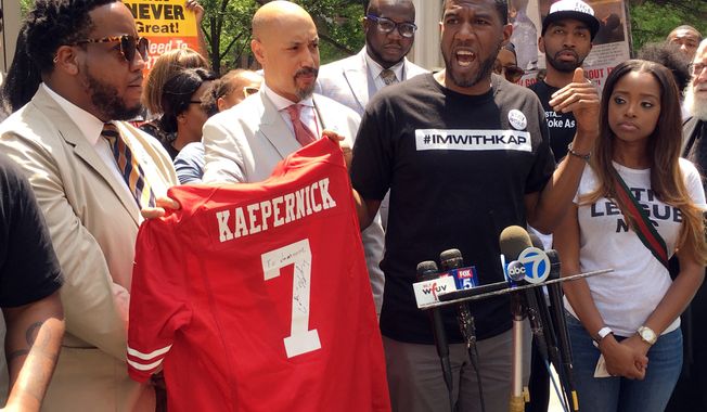New York Councilman Jumaane D. Williams, second from right, with the help of  Kirsten John Foy, second from left, Northeast Regional Director of the National Action Network, holds a jersey with Colin Kaepernick&#x27;s name on the back, during a rally of civil rights activists outside of the NFL’s headquarters, Friday, May 25, 2018, in New York. About 50 people gathered to protest the NFL’s new policy aimed at ending player protests during the playing of the national anthem in stadiums before games. Kaepernick, the former San Francisco 49ers quarterback, started the movement of taking a knee during the anthem to protest police brutality and racial inequality two seasons ago. (AP Photo/Ralph Russo)