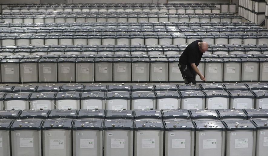 Election warehouse manager Michael Leonard checks the seals on the ballot boxes in Dublin, Thursday May 24, 2018, ready to be delivered to polling stations for Friday's referendum on the 8th Amendment of the Irish Constitution. (Niall Carson/PA via AP)