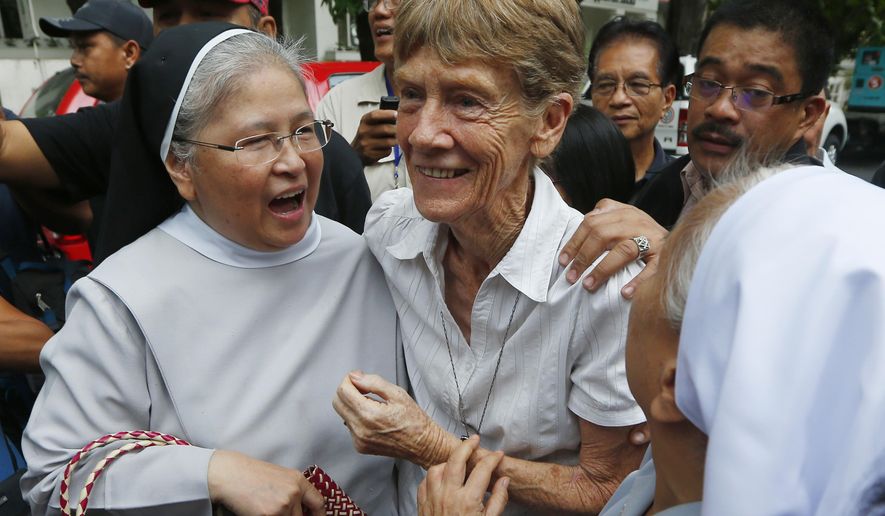 Australian Roman Catholic nun Sr. Patricia Fox, center, is greeted by fellow nuns as she arrives to file her at the Justice Department shortly after filing a petition seeking to review a Bureau of Immigration order revoking her missionary visa, Friday, May 25, 2018, in Manila, Philippines. Sr. Pat, who irked the Philippine president for joining political rallies, has defied an Immigration Bureau order for her to leave the Philippines and appealed to justice officials to allow her to continue her missionary work for the poor and victims of injustice. (AP Photo/Bullit Marquez)