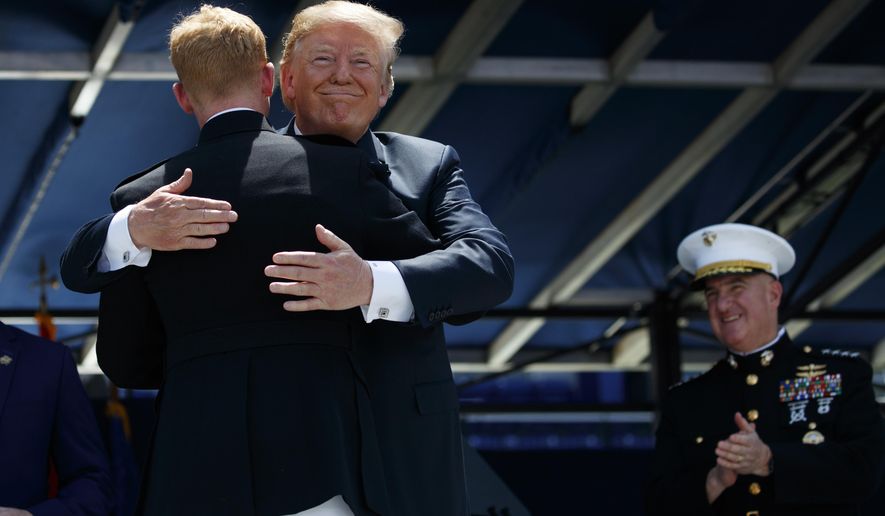 President Donald Trump embraces the last graduate in line during a graduation and commissioning ceremony at the U.S. Naval Academy, Friday, May 25, 2018, in Annapolis, Md. (AP Photo/Evan Vucci)