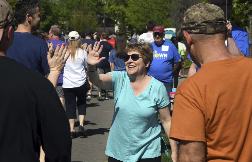 In this May 6, 2018 photo, Democratic congressional candidate Lisa Brown, center, who is challenging U.S. Rep. Cathy McMorris Rodgers, R-Wash., greets walkers at the Lilac Bloomsday Run in Spokane, Wash. President Donald Trump&#39;s unwillingness to release his tax returns is helping renew a debate on whether the practice should be expected of elected federal office holders ahead of this year&#39;s midterms, and in April, 2018, McMorris Rodgers released her returns for the first time since winning the House seat in 2004. (Dan Pelle/The Spokesman-Review via AP)