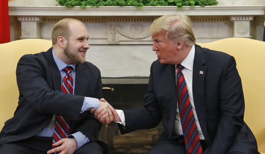 President Donald Trump shakes hands with Joshua Holt, who was recently released from a prison in Venezuela, in the Oval Office of the White House, Saturday, May 26, 2018, in Washington. (AP Photo/Alex Brandon)